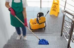 Image of a janitorial cleaning professional mopping a floor.