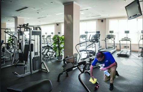 professional commercial cleaner cleaning a gym equipment