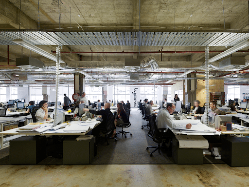 a large busy office floor with dozens of employees working at their desks
