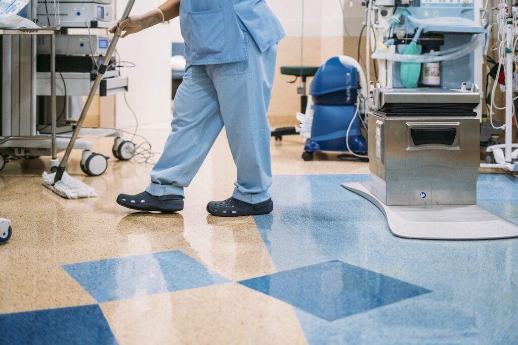 A hospital worker doing cleaning in operation room.