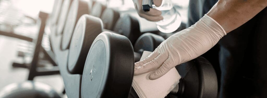 gym cleaning company woman cleaning gym equipment