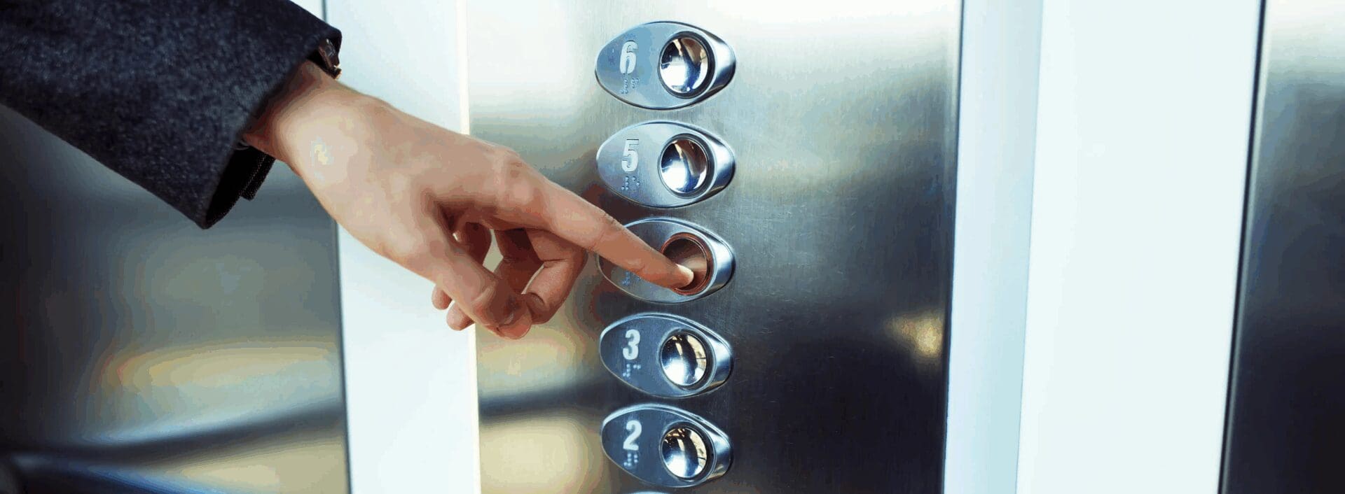 person touching elevator buttons