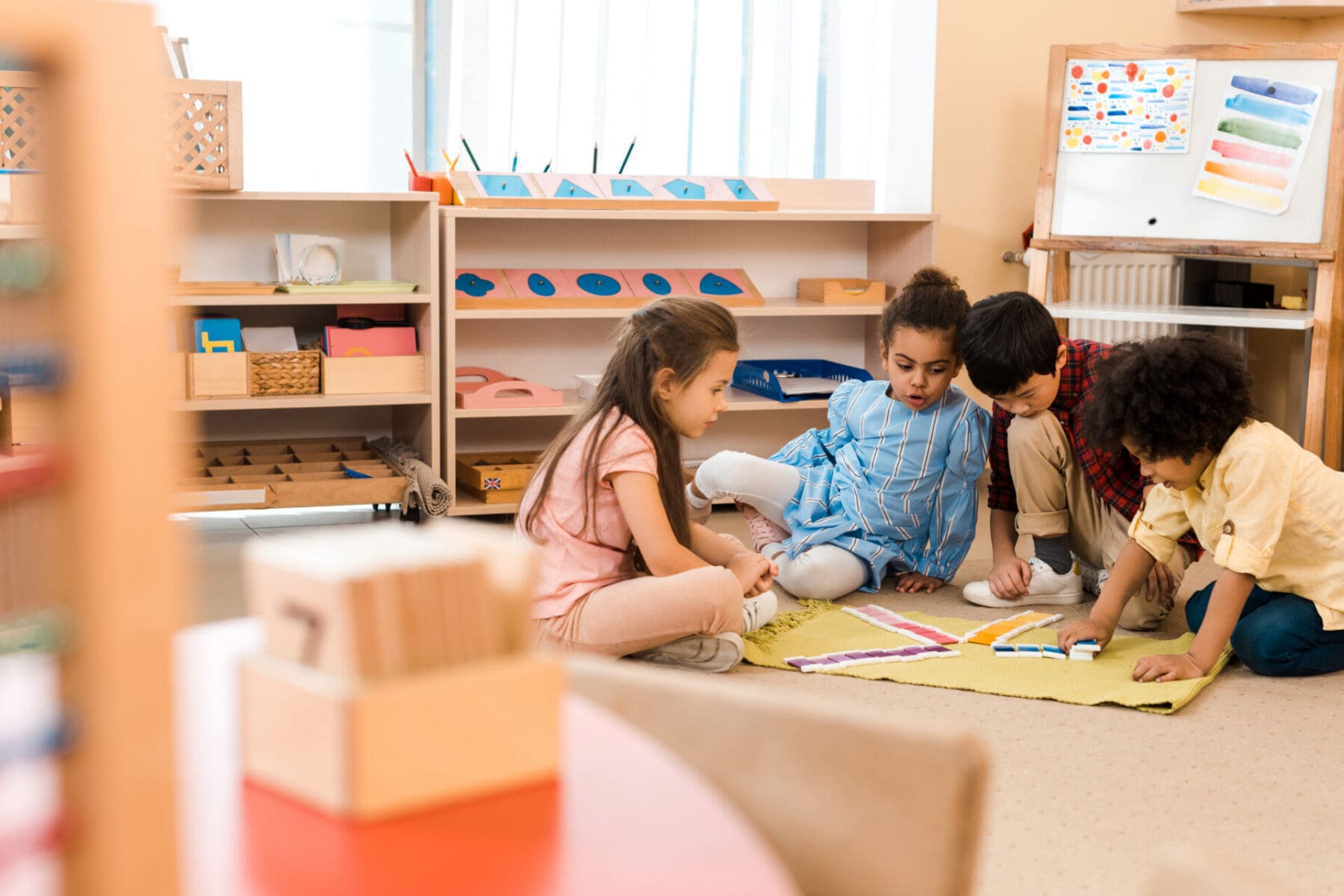 Selective focus of children playing game on floor in montessori school kids in a daycare